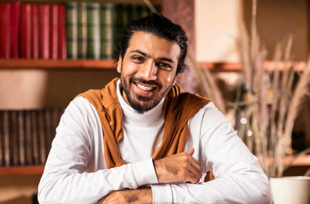 Portrait Of Young Arab Teacher Sitting At Workplace Indoorsの写真素材