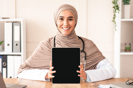 Cheerful female doctor showing digital tablet with blank screenの写真素材