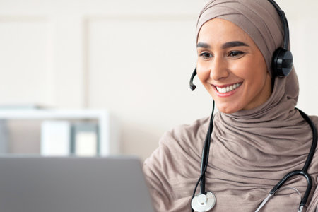Cheerful muslim lady doctor having video chat with patientの写真素材