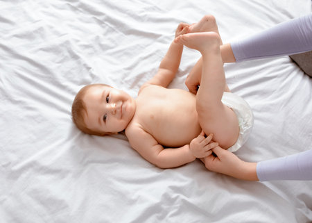 Mother changing babys diaper on white, top viewの写真素材