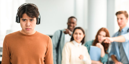 People mocking and making fun of sad asian manの写真素材