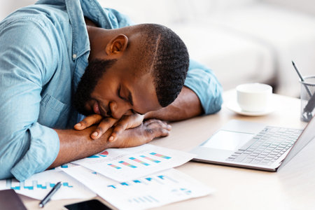 Sleep At Work. Exhausted black freelancer napping at desk at home officeの写真素材