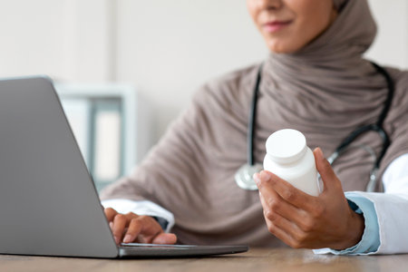 Cropped of female doctor with medicine using laptopの写真素材