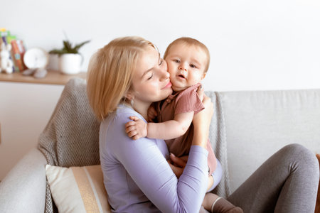 Affectionate young mother cuddling with her little baby