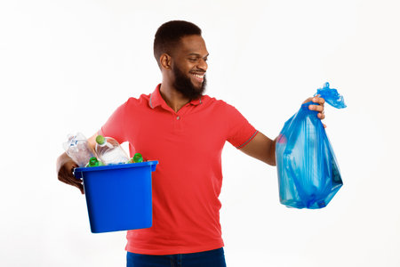 African American Man Holding Garbage Bag And Box, White Backgroundの写真素材