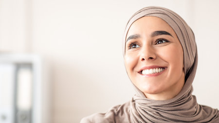 Joyful arab woman in hijab looking at copy spaceの写真素材