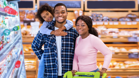 Portrait of happy black family posing together at grocery storeの写真素材