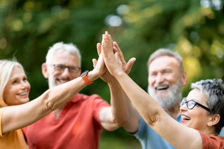 Portrait Of Happy Mature People Giving High Five To Each Other Outdoorsの写真素材