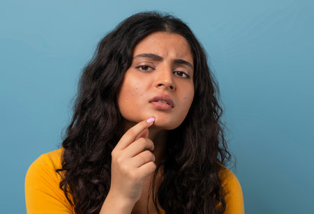 Stressed sad brunette young woman touching her faceの写真素材