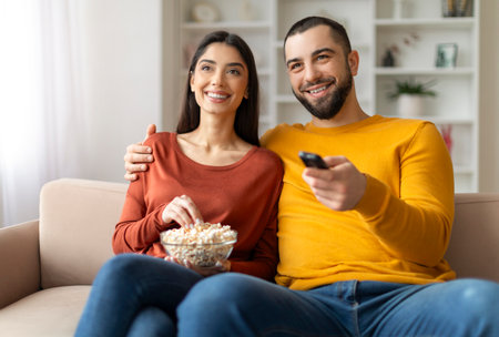 Home Relax. Happy Young Married Couple Watching Tv In Living Room