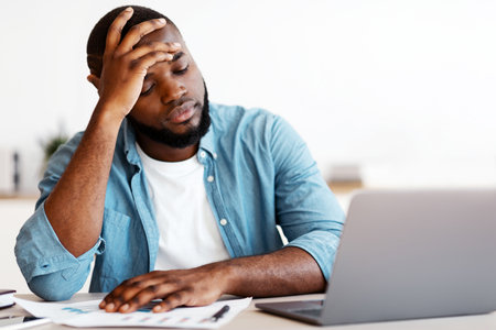 Stressed Black Male Entrepreneur Having Problems At Work, Sitting Upset In Office