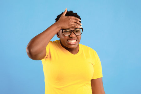 Sick African Woman Having Fever Touching Forehead Over Blue Backgroundの写真素材