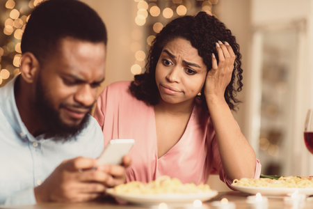Unhappy Black Woman Bored On Date, Man Using Phoneの写真素材
