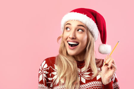 Excited lady in Christmas outfit writing New Year resolutions in copybook on pink background, banner design, copy spaceの写真素材