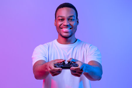 Modern Entertainment. Smiling Black Guy In Neon Light With Joystick In Handsの写真素材