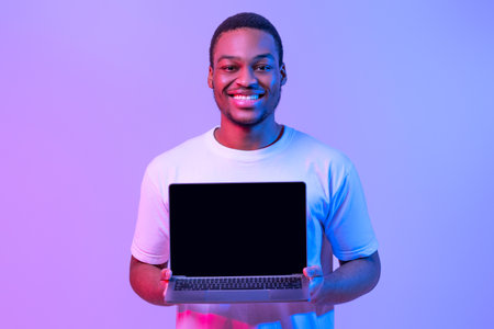 New Website. Happy African American Man Holding Laptop Computer With Black Screen