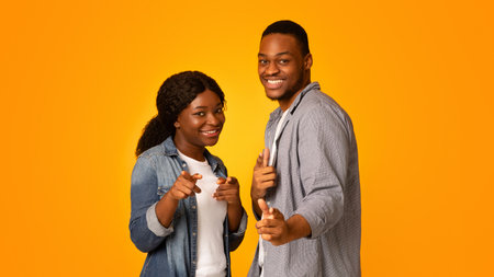 Positive African American Couple Pointing At Camera With Two Handsの写真素材