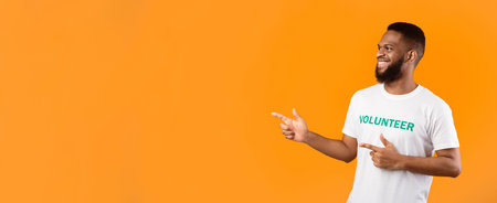 African Volunteer Pointing Fingers Aside At Empty Space, Yellow Background