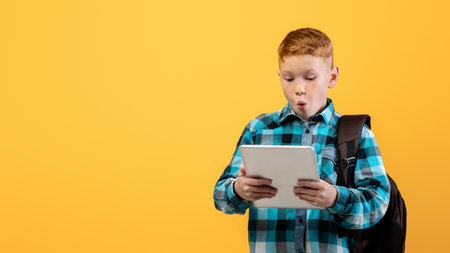 Amazed boy schooler with backpack using digital tablet