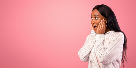Excited African American woman looking at blank space on pink studio background, panorama