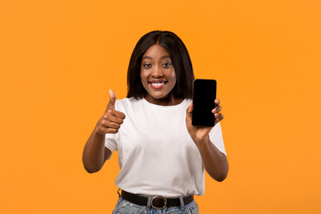 Smiling black lady showing mobile phone with empty screen