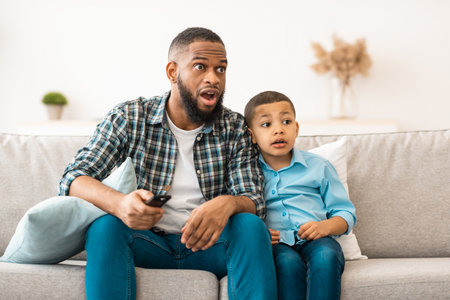 Confused Dad And Son Watching TV, Switching Questionable Content Indoorの写真素材