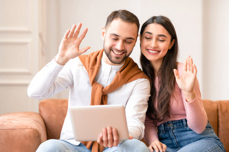 Arab Couple Making Video Call Via Digital Tablet At Homeの写真素材