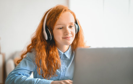 Girl wearing headphones using laptop for online education