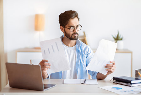 Busy Arab Male Entrepreneur Working With Papers And Laptop In Office