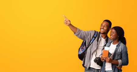 Hot Tours Offers. Couple Of Black Tourists Pointing Aside At Copy Spaceの写真素材