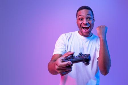 Video Gaming Concept. Euphoric African American Guy With Joystick Celebrating Game Winの写真素材