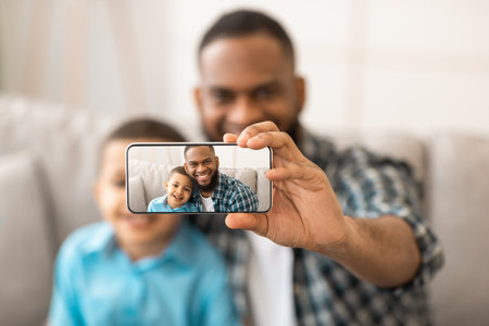 African Father And Son Making Selfie On Smartphone At Homeの写真素材