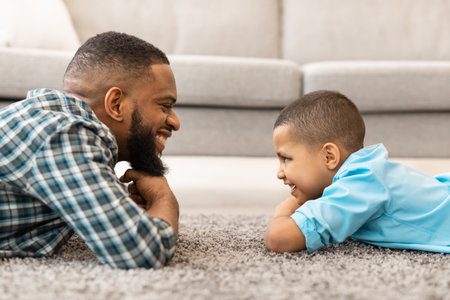 African Daddy And Son Looking At One Another At Homeの写真素材