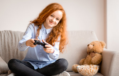 Teen girl playing a video game with controllerの写真素材