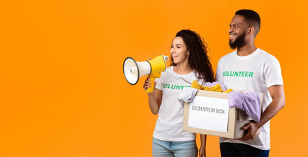 Two Diverse Volunteers Holding Donation Box, Studio Shot, Panoramaの写真素材