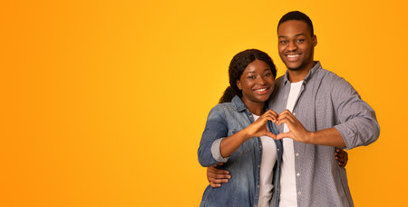 Portrait Of Happy Romantic Black Couple Making Heart Gesture With Their Handsの写真素材