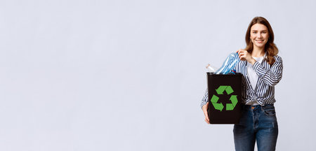 Millennial woman promoting eco-friendly recycling habits with a smileの写真素材