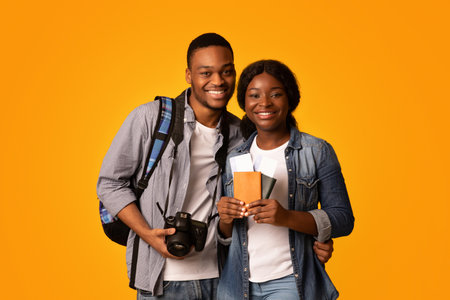 Tourists Couple. Happy african lovers holding passports with tickets and photo cameraの写真素材