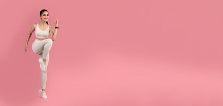 Young Woman Doing High Knees Exercise Isolated On Pink Backgroundの写真素材