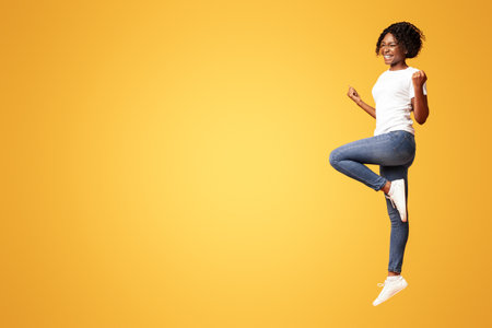 Black lady winner jumping up and showing funny figuresの写真素材