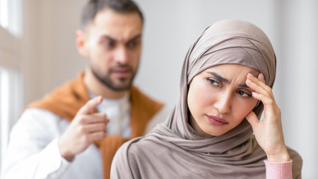 Aggressive Muslim Husband Shouting At Depressed Wife Standing At Homeの写真素材