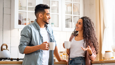 Millennial Middle Eastern Couple Spending Time In Kitchen, Drinking Coffee And Chattingの写真素材