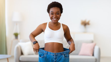 Thin Lady Wearing Large Jeans Showing New Small Size Indoorsの写真素材