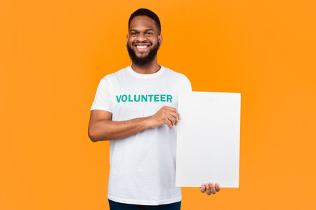 African Volunteer Man Showing Blank White Board Over Yellow Background