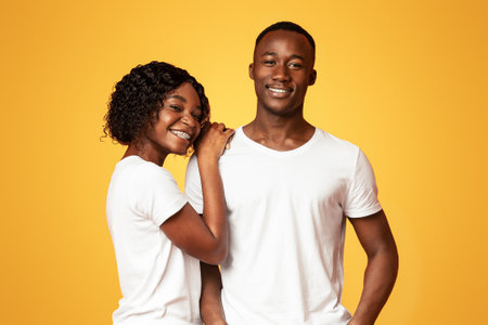 Loving black couple posing together on orange