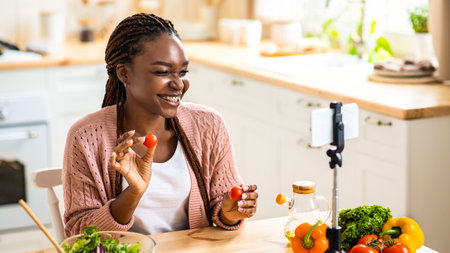 Online Nutritionist. Cheerful Young Black Female Recording Food Review In Kitchenの写真素材
