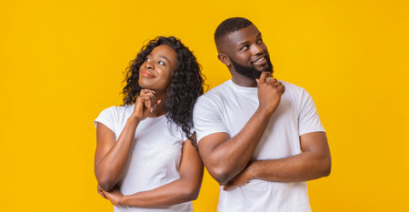 Young couple day dreaming on yellow background