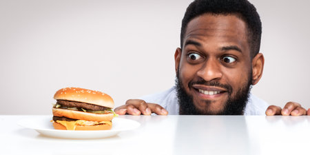 Funny Hungry Black Man Looking At Burger Over White Backgroundの写真素材