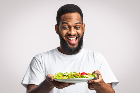 Excited African Bearded Guy Holding Salad Standing Over White Backgroundの写真素材