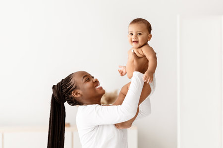 Black woman playing with her cute little babyの写真素材